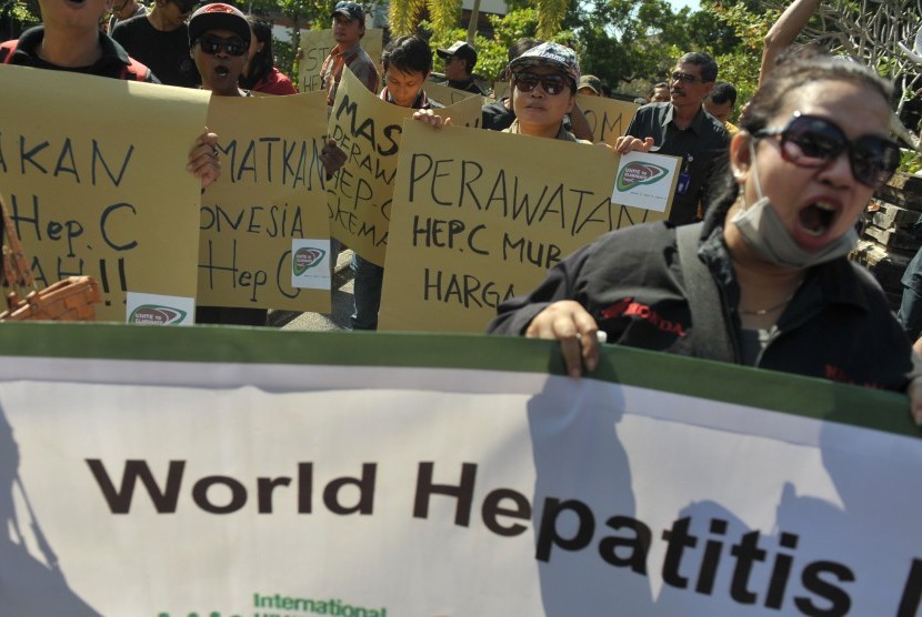 Sejumlah pengunjuk rasa membentangkan tulisan saat menggelar aksi memperingati Hari Hepatitis se-dunia di Denpasar, Selasa (28/7). 