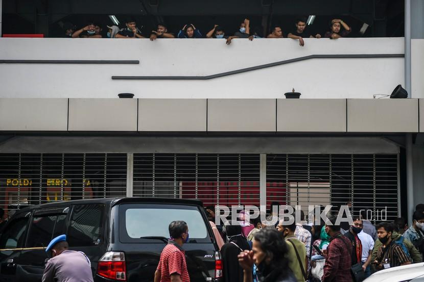 Sejumlah pengunjuk rasa yang menolak UU Cipta Kerja (atas) berada di Gedung Parkir Barang Bukti Ranmor di Polda Metro Jaya, Jakarta, Jumat (9/10/2020). Mereka diamankan petugas Kepolisian karena diduga terlibat kericuhan saat unjuk rasa menolak UU Cipta Kerja pada Kamis (8/10). 