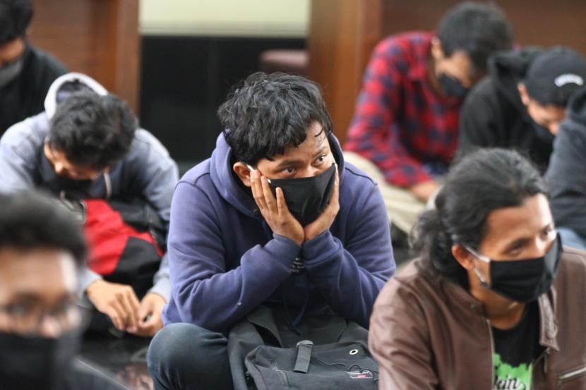 Sejumlah pengunjuk rasa yang menolak UU Cipta Kerja diamankan di aula Polresta Malang, Jawa Timur, Jumat (9/10/2020). Sebanyak 129 pengunjuk rasa yang sebagian besar adalah pelajar tersebut ditangkap karena diduga terlibat dalam aksi perusakan dan pembakaran kendaraan serta fasilitas umum.