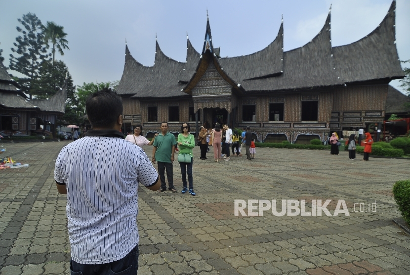  Sejumlah pengunjung berfoto Anjungan Sumatra Barat di Taman Mini Indonesia Indah, Jakarta Timur, Rabu (5/7).