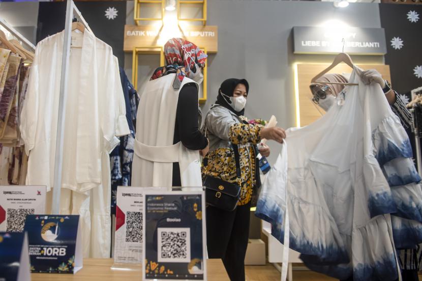Sejumlah pengunjung melihat-lihat pakaian yang dijual di salah satu stan peserta Indonesia Sharia Economic Festival (ISEF) ke-8 Tahun 2021 di Jakarta Convention Center (JCC), Senayan, Jakarta, Rabu (27/10/2021). Kementerian Perindustrian RI memasang target pembentukan Global Halal Hub Indonesia pada 2024.