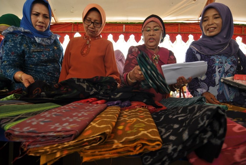 Sejumlah pengunjung memilih kain sutra tenun Donggala yang dijual dalam sebuah pameran di Palu, Sulawesi Tengah.
