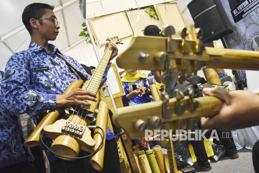 Sejumlah pengunjung mencoba alat musik gitar berbahan bambu di Virageawie Indonesia pada Pameran UMKM di area Komplek Perkantoran Pemda Kabupaten Bandung Barat, Rabu (19/6). 