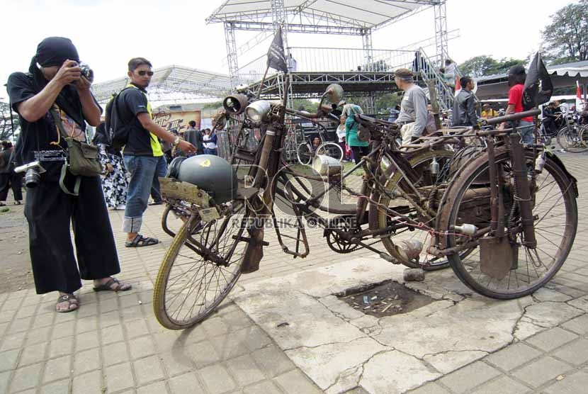  Sejumlah pengunjung mengamati sepeda pengangkut amunisi dalam kondisi masih asli pada acara 'Bandung Lautan Onthel' di kawasan Lapangan Gasibu,Bandung, Ahad (24/3).  (Republika/Edi Yusuf)