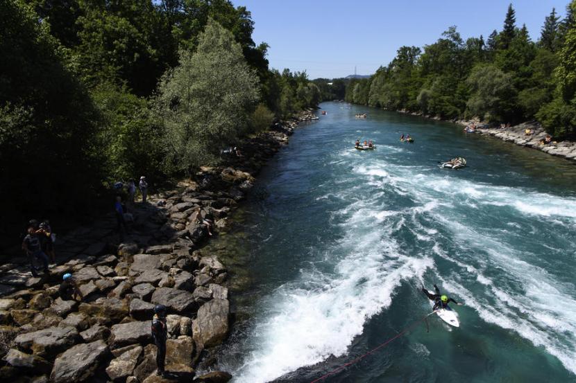 Sejumlah pengunjung menikmati arus Sungai Aare di Swiss dengan berselancar. Pencarian Emmeril Khan putra Ridwan Kamil yang hilang di Sungai Aare Swiss terus dilakukan 
