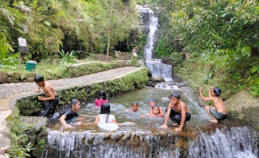 Sejumlah pengunjung menikmati kesegaran air di Curug Tirta Wening di Dusun Cemanggal, Desa Munding, Kecamatan Bergas, Kabupaten Semarang, Ahad (12/6). Potensi wisata ini teru dikembangkan sebagai keragaman daya tarik kunjungan di Desa Wisata Munding.