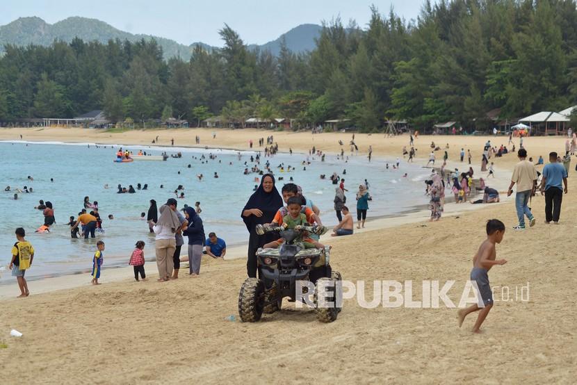 Sejumlah pengunjung menikmati liburan di pantai wisata Lampuuk, Kecamatan Lhoknga, Kabupaten Aceh Besar, Aceh. Pengamat menilai libur Lebaran tahun ini dapat membangkitkan gairah sektor pariwisata. Ilustrasi.