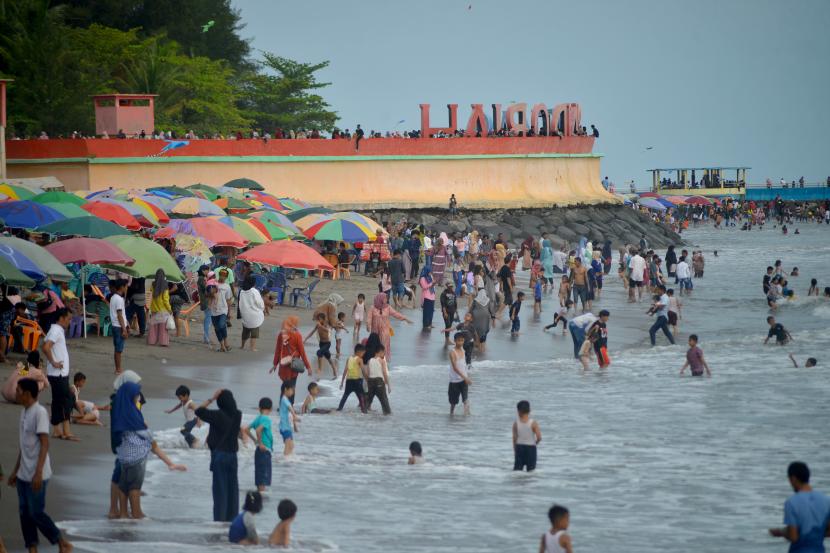 Sejumlah pengunjung menikmati wisata di Pantai Gandoriah, Pariaman, Sumatera Barat.