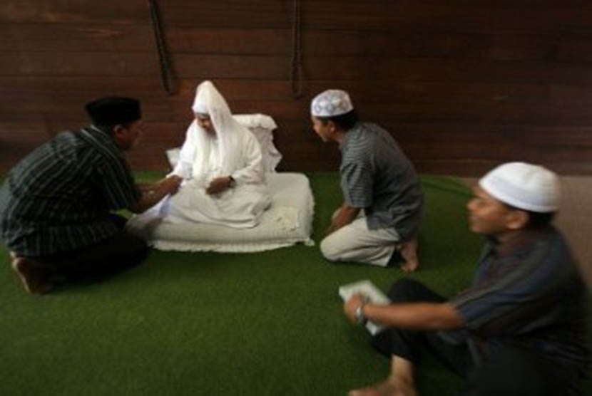Sejumlah pengunjung menyalami Tuan Guru Syekh H Hasyim Al-Syarwani (tengah) keturunan ke-11 dari Tuan Guru Syekh Abdul Wahab Rokan saat berwisata religi di Pesantren Babussalam, Kabupaten Langkat, Sumut. 