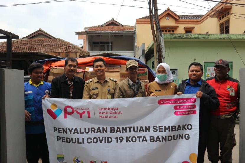 Sejumlah Pengurus LAZ Panti Yatim Indonesia bersama Camat Regol Iwan Sumaryana (ketiga kiri) saat menyalurkan Program Ketahanan Pangan kepada warga dhuafa yang terdampak covid-19 di Kecamatan Regol, Kota Bandung, Senin (30/3). 