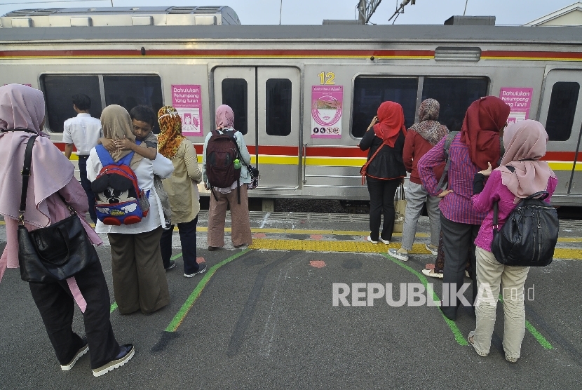  Sejumlah penumpang berdiri di garis antrean penumpang saat menunggu KRL di Stasiun Juanda, Jakarta, Selasa (8/8). 