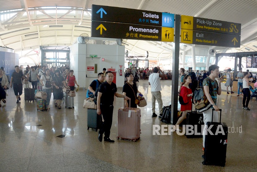Sejumlah penumpang beristirahat menunggu jadwal penerbangan di Bandara Ngurah Rai, Bali, Jumat (29/6).