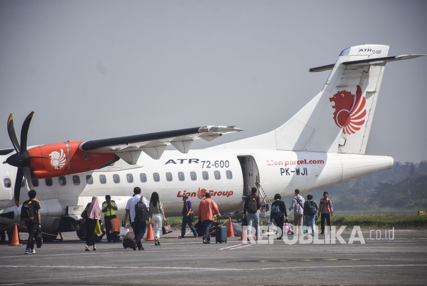 Sejumlah penumpang berjalan menuju pesawat di Bandara Husein Sastranegara, Kota Bandung, Senin (1/7).