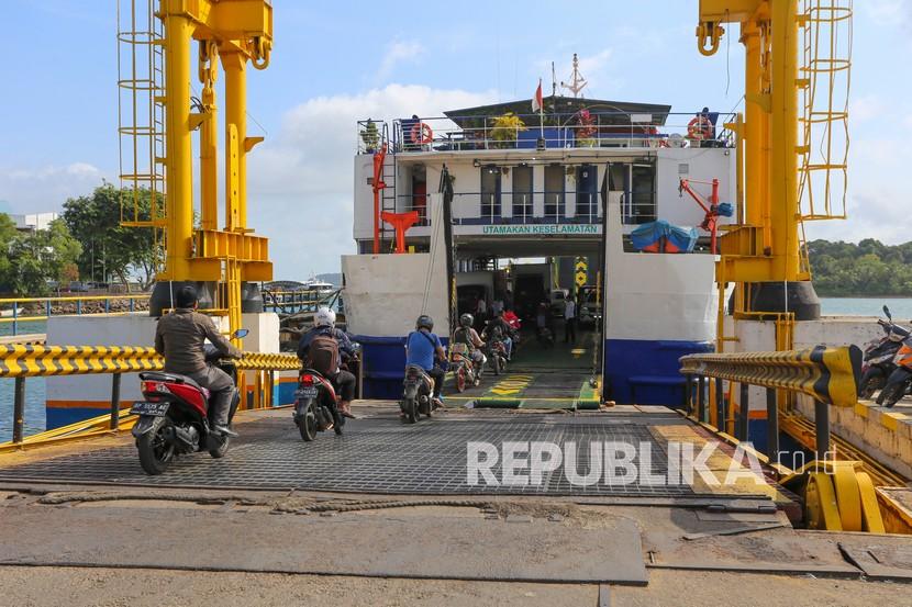 Sejumlah penumpang bersepeda motor antre masuk ke kapal KMP Barau di Pelabuhan ASDP Telaga Punggur, Batam, Kepulauan Riau, Jumat (21/1/2022). 