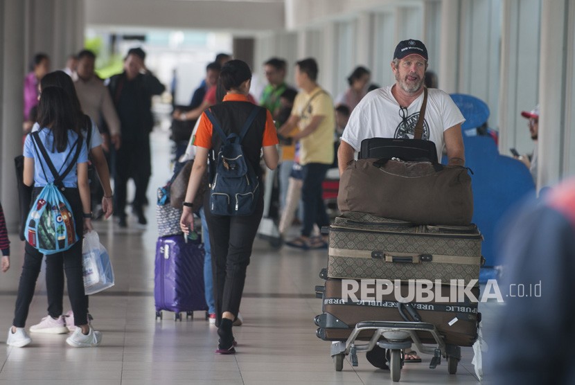 Sejumlah penumpang membawa barang bawaan di Terminal Domestik Bandara Ngurah Rai.