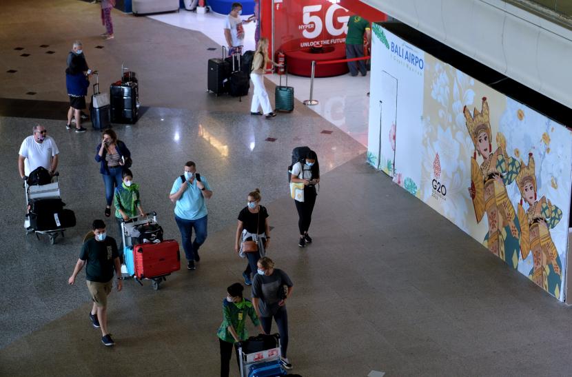 Sejumlah penumpang pesawat membawa barang bawaannya di area Terminal Internasional Bandara I Gusti Ngurah Rai, Badung, Bali, Kamis (29/9/2022). 