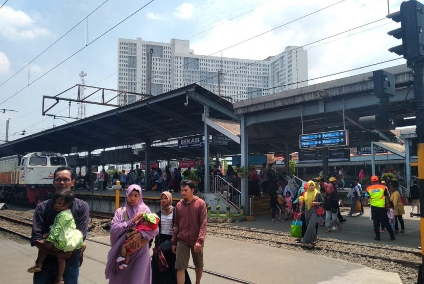 Sejumlah penumpang sedang melintasi rel kereta di Stasiun Bekasi, Kota Bekasi, pada Ahad (14/4). Tampak Stasiun Bekasi sudah tidak mengalami penumpukan lagi meski uji coba jalur dwi ganda masih berlangsung.