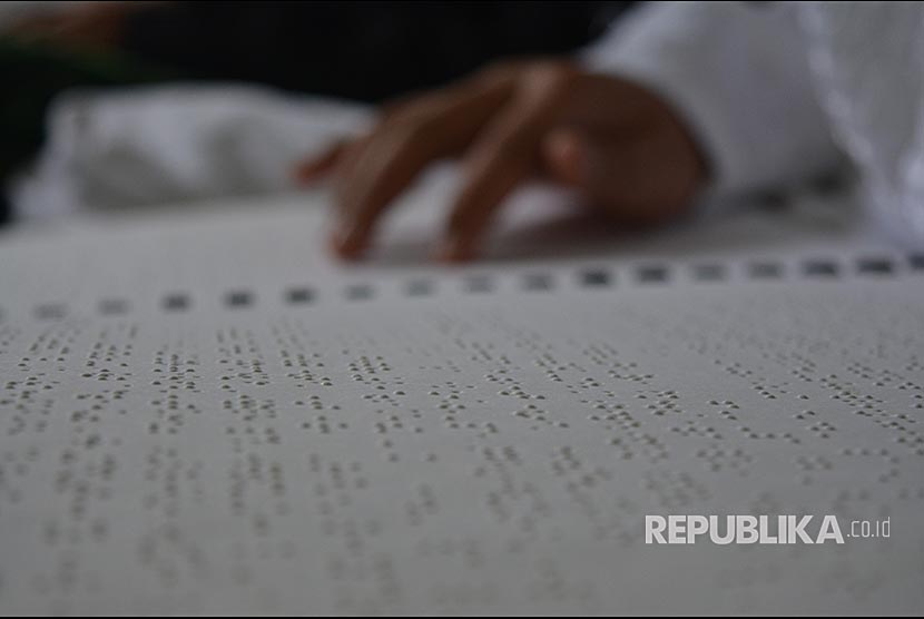 Jemari seorang penyandang tunanetra bergerak membaca Braille 