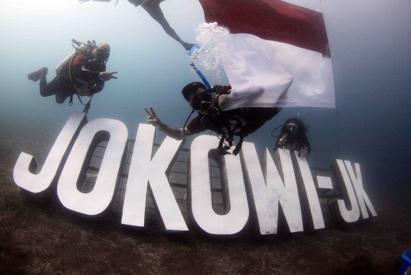 Sejumlah penyelam memasang tempat transplantasi terumbu karang berbentuk tulisan calon presiden dan wakil presiden Jokowi-Jk ketika transplantasi terumbu karang oleh tim relawan Jokowi-Jk di Pantai Malalayang, Manado, Sulawesi Utara, Selasa (1/7)