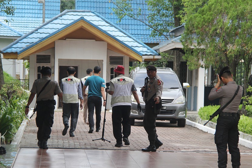 Sejumlah penyidik Komisi Pemberantasan Korupsi (KPK) dan aparat kepolisian berjalan menuju tempat parkir mobil rumah dinas Wali Kota Dumai saat akan dilakukan penggeledahan di kota Dumai, Riau, Jumat (26/4/2019).