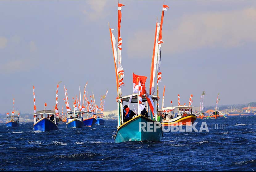 Sejumlah perahu nelayan melakukan parade Kemerdekaan di Pantai Watu Dodol, Banyuwangi, Jawa Timur, Sabtu (12/10). Sebanyak 72 kapal nelayan dan wisata mengikuti Parade Kemerdekaan dalam merayakan HUT Ke-72 Kemerdekaan RI. 
