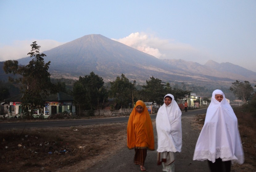 Sejumlah warga berjalan dengan latar belakang Gunung Rinjani di Desa Sembalun Lawang, Kecamatan Sembalun, Selong, Lombok Timur, NTB