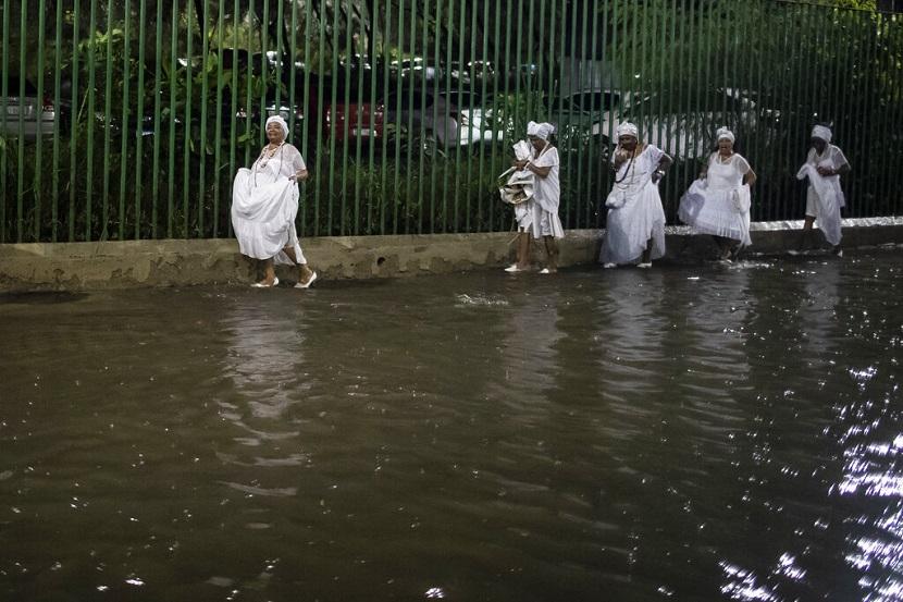 Sejumlah perempuan Brasil berjalan di jalan yang digenangi hujan lebat setelah melakukan ritual pra-karnaval di Rio de Janeiro, Brasil, Sabtu, 11 Februari 2023. Perayaan Karnaval yang terkenal di dunia di Rio de Janeiro akan diadakan mulai 17-25 Februari. 