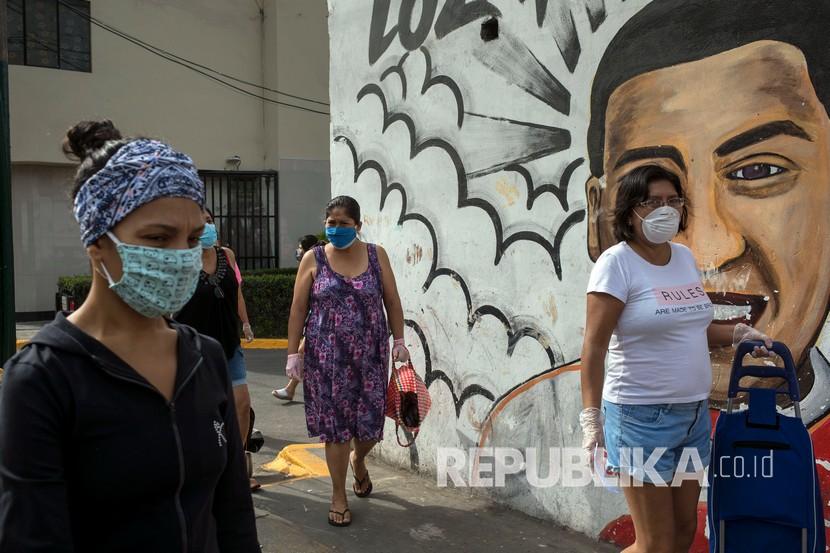 Sejumlah perempuan memakai masker dan sarung tangan  menunngu antream untuk membeli makanan di pasar popular, Lima, Peru, Sabtu (4/4). Pemerintah membatasi pergerakan warga berdasarkan gender imbas dari penyebaran virus Corona. Hari Sabtu diperuntukan bagi perempuan yang bisa meninggalkan rumah untuk membeli kebutuhan barang pokok. 