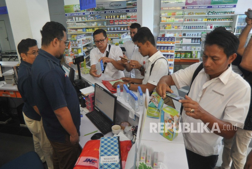 Sejumlah personel Ditreskrimsus Polda Sumbar, mengecek stok masker yang ada di sebuah apotek, di Padang, Sumatera Barat, Rabu (4/3/2020).