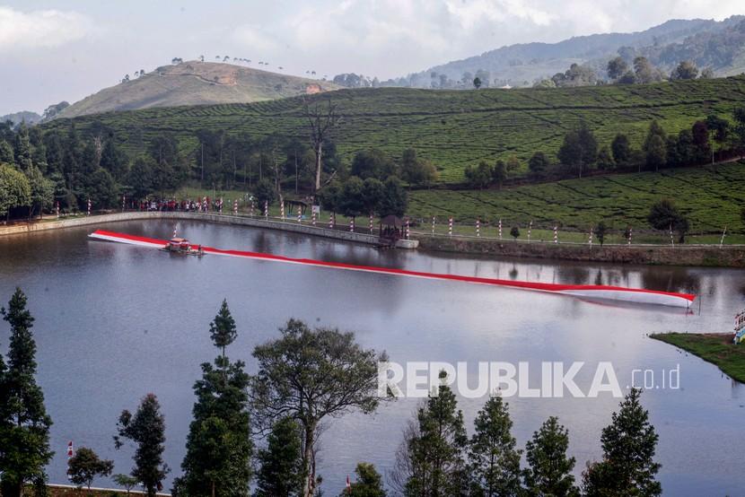 Personel Kopassus membentangkan kain merah putih di titik nol Ciliwung, Telaga Saat, kawasan Puncak, Kecamatan Cisarua, Kabupaten Bogor, Jawa Barat.