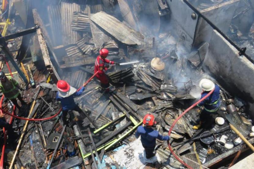 Sejumlah personel pemadam kebakaran melakukan proses pendinginan usai kebakaran menghanguskan enam unit rumah dan satu gudang di di Jalan Barukang lorong 15, RT/RW 01/01, Kelurahan Cambayya, Kecamatan Ujung Tanah, Makassar, Sulawesi Selatan, Jumat (8/9/2023). 