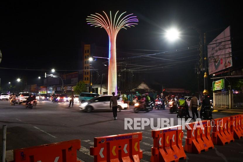 Sejumlah personel polisi mengatur lalu lintas di lokasi penutupan akses menuju Alun-alun Kota Madiun, Jawa Timur, Jumat (31/12/2021) malam. Seluruh akses menuju alun-alun di kota tersebut ditutup menggunakan road barrier dan dijaga polisi saat menyambut pergantian tahun 2021-2022 guna menghindari kerumunan karena masih dalam masa pandemi COVID-19. 