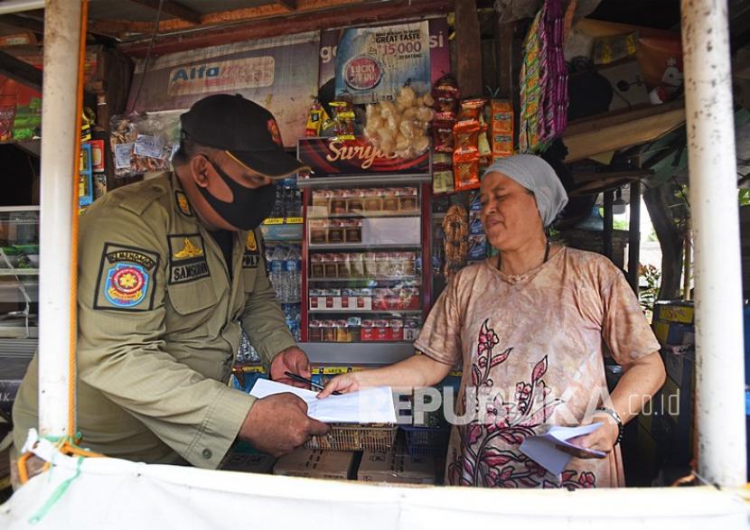 Sejumlah personel Satuan Polisi Pamong Praja menegur dan mendata pedagang yang kedapatan mengabaikan protokol kesehatan. 