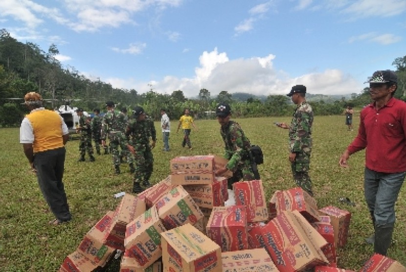 Sejumlah personel TNI AD dari Yonif 711 Raksatama bersama warga menurunkan logistik bantuan dari helikopter di Desa Langko, Kecamatan Lindu, Kabupaten Sigi, Sulawesi Tengah, Rabu (22/8).