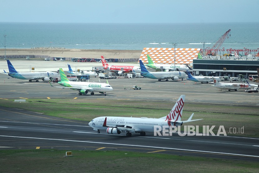Sejumlah pesawat udara berada di apron dan landasan Bandara Internasional I Gusti Ngurah Rai, Bali, Selasa (17/12/2019). 
