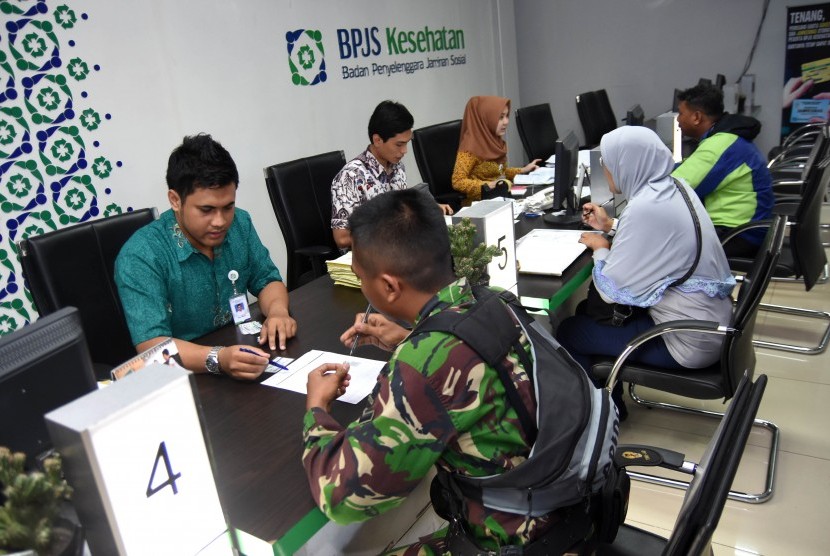  Sejumlah peserta antre untuk melakukan pendaftaran dan pembaruan data di Badan Penyelenggara Jaminan Sosial (BPJS) Kesehatan KCU Surabaya, Jawa Timur, Rabu (29/7). 