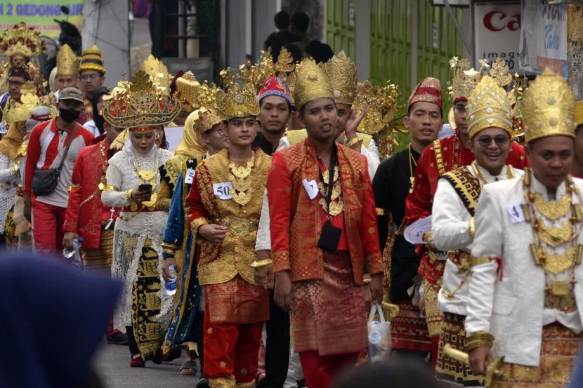 Kongres Bahasa Lampung Pertama Gali Budaya Bangsa. Foto:   Sejumlah peserta berkostum adat Lampung berpawai keliling Kota Bandar Lampung di Lampung, Ahad (31/7/2022). Pawai yang diikuti sejumlah instansi pemerintah, OPD, pelajar dan umum tersebut menampilkan sebanyak 164 kendaraan hias dalam rangka memperingati Hari Jadi ke-340 Kota Bandar Lampung. 