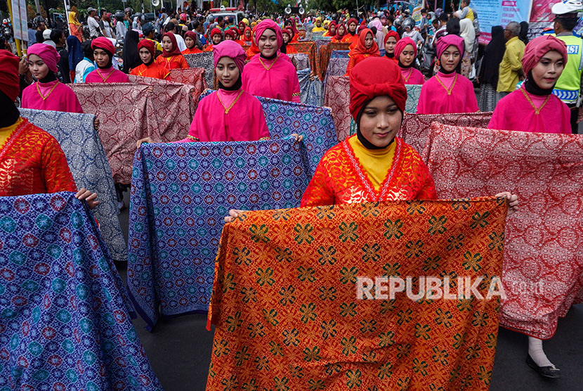 Sejumlah peserta kirab membawa kain batik corak Jlamprang saat kirab budaya tradisi syawalan di Pekalongan, Jawa Tengah, Kamis (21/6).