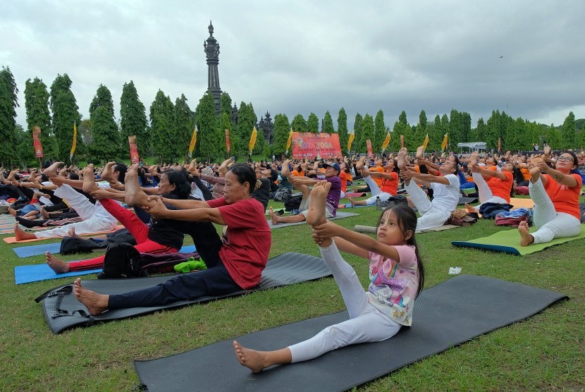 Sejumlah peserta melakukan gerakan yoga di Denpasar, Bali.