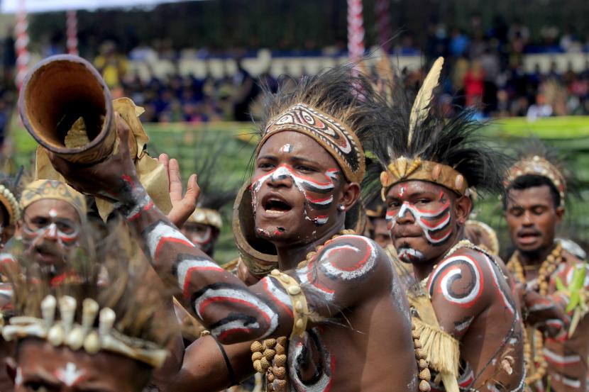 Sejumlah warga menampilkan tarian adat Papua sambil memukul tifa (ilustrasi).