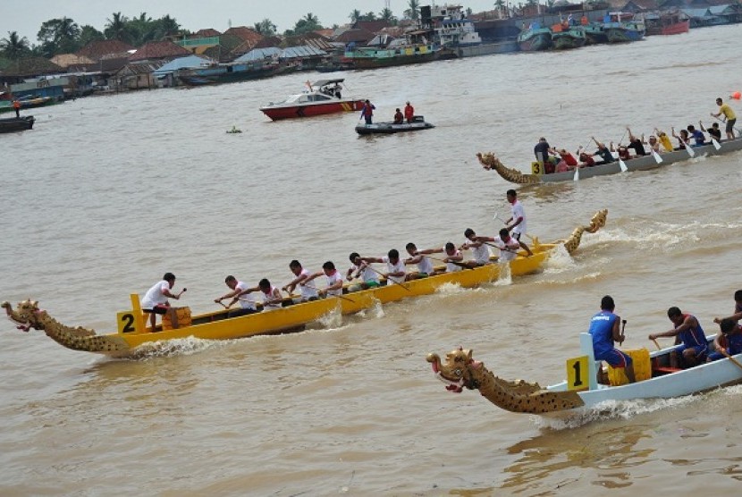 Sejumlah peserta mengayuh perahu naga pada etape akhir balap perahu naga yang merupakan rangkaian akhir dari Musi Triboatton 2012 di Benteng Kuto Besak Palembang, Sabtu (1/12). 