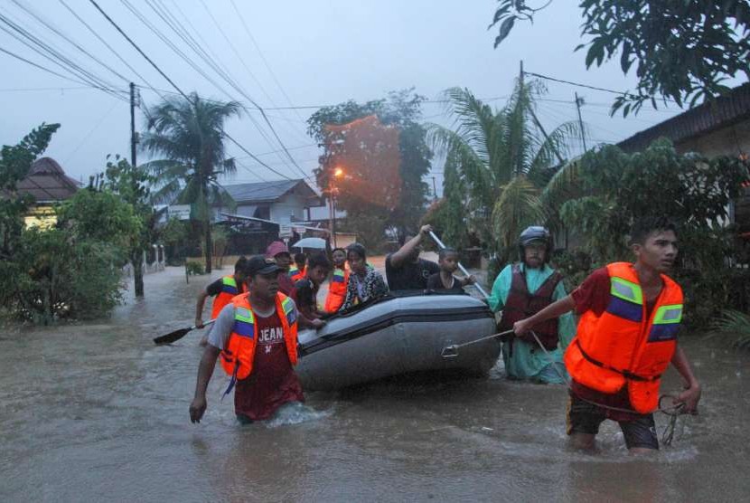 Sejumlah petugas Badan Penanggulangan Bencana Daerah (BPBD) mengevakuasi warga yang terimbas banjir di daerah Jondul Rawang Barat, Padang, Sumatera Barat, Rabu (26/9). 