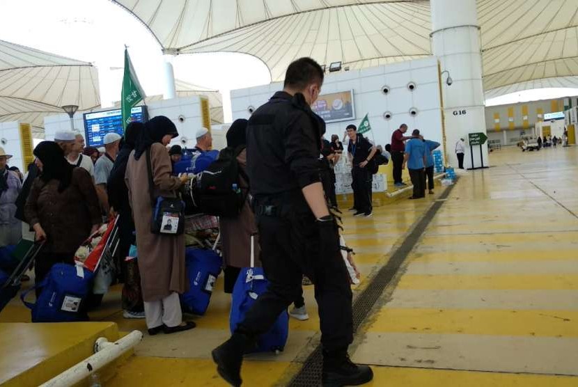 Sejumlah petugas berseragam nampak mengawasi jamaah haji Cina di Bandara Kingabdulaziz, Jeddah, Kamis (30/1). Tanpa emblem kesatuan dan hanya dilengkapi badge bendera Cina, mereka mengawal para jamaah hingga ke pesawat.