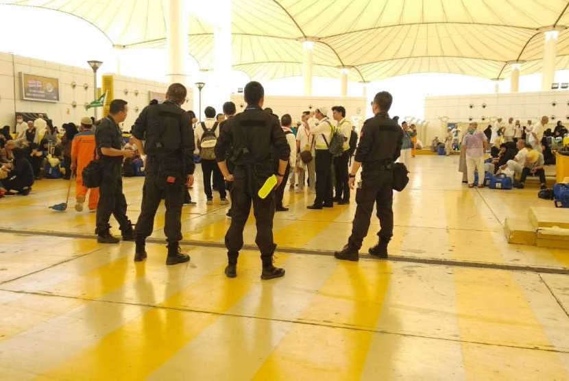 Sejumlah petugas berseragam nampak mengawasi jamaah haji Cina di Bandara Kingabdulaziz, Jeddah, Kamis (30/1). Tanpa emblem kesatuan dan hanya dilengkapi badge bendera Cina, mereka mengawal para jamaah hingga ke pesawat.
