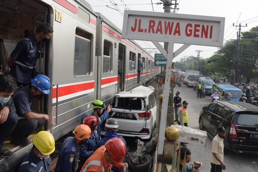 Sejumlah petugas berusaha mengevakuasi mobil Honda Mobilio yang tertabrak KRL Commuterline KA 1077 (Bogor-Jakarta Kota) di kawasan Rawageni, Ratu Jaya, Cipayung, Depok, Jabar, Rabu (20/4/2022). Kecelakaan yang terjadi di perlintasan sebidang itu menyebabkan terganggunya perjalanan KRL karena kereta harus melaju di satu jalur secara bergantian.