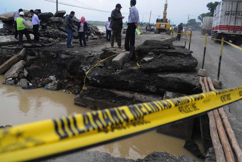   Sejumlah petugas Bina Marga dan Dinas Pekerjaan Umum Cirebon memantau jalur Pantura yang amblas di Desa Mandalawangi, Kecamatan Ciasem, Subang, Jawa Barat, Rabu (22/1).   (Antara/Novrian Arbi)