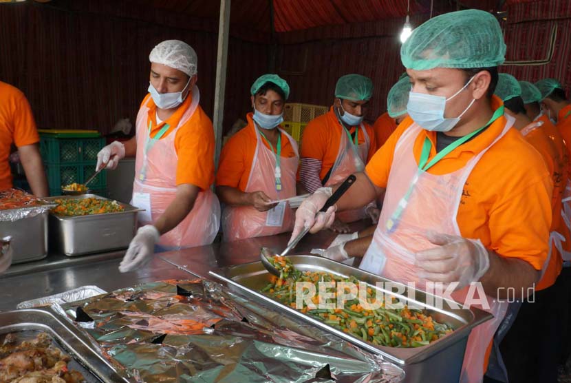  Sejumlah petugas dari salah satu perusahaan katering yang memasok makanan bagi jamaah haji Indonesia di Arafah, Sabtu (10/9), mengemas makanan di dapur umum pada perkemahan maktab. (Republika/Amin Madani)