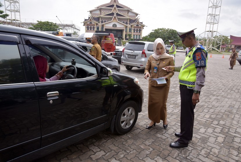 Sejumlah petugas dari Tim Pembina Samsat Provinsi Riau memeriksa pajak kendaraan warga saat operasi penertiban pajak kendaraan di Kota Pekanbaru, Selasa (16/10/2018). 