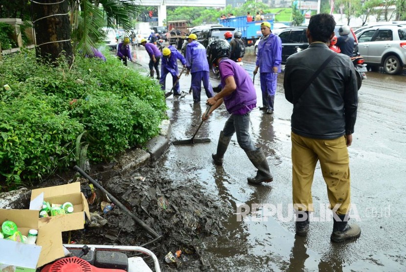 Sejumlah petugas membersihkan lumpur sisa banjir luapan drainase dan sungai, di Jl Pasteur, Kota Bandung, Senin (24/10). (Republika/Edi Yusuf)