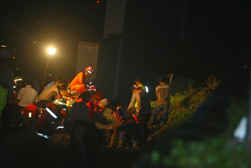 Sejumlah petugas gabungan dari badan SAR, TNI, Kepolisian dan Pemadam Kebakaran Bandara Soetta melakukan evakuasi terhadap korban longsor tembok under pass perlintasan Kereta Bandara Soetta di kawasan Parimeter Selatan, Bandara Soekarno Hatta, Tangerang, Banten, Senin (5/2) malam. 